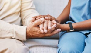 concept image of elderly care facility nurse and patient holding hands