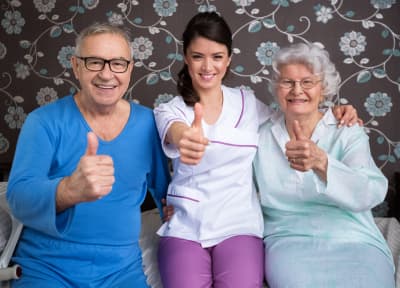 image of two elderly people with caregiver smiling image of two elderly people with caregiver smiling